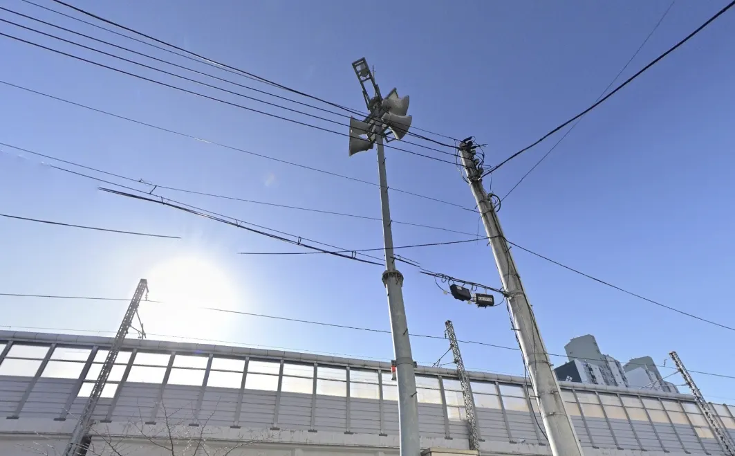 Observation device on a utility pole next to a noise barrier